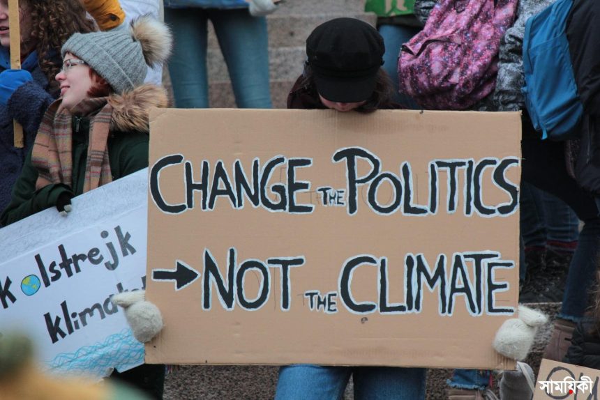 person holding change the politics not the climate printed board