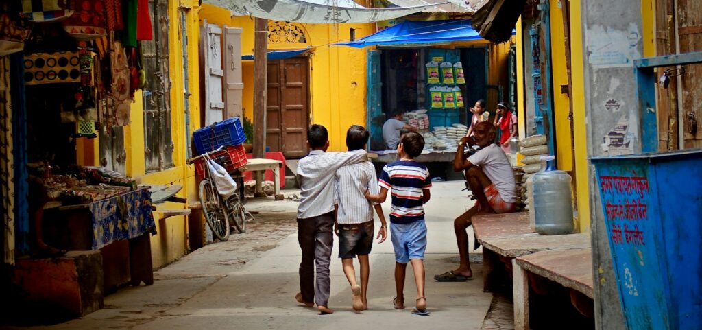 three boys walking between buildings at daytime