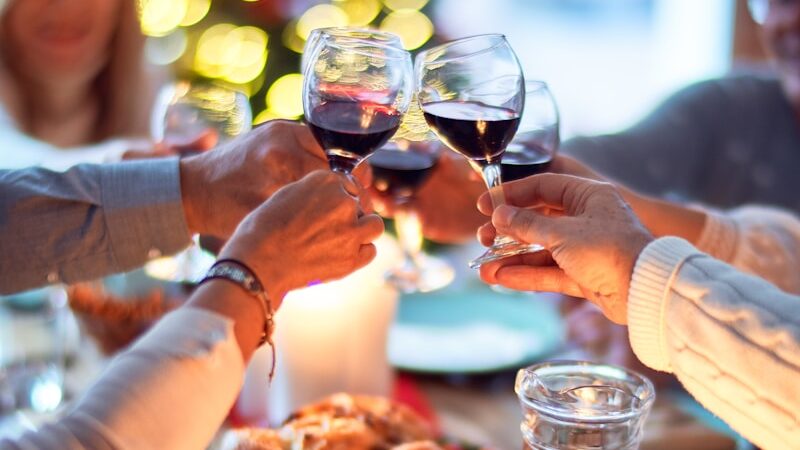 woman in white long sleeve shirt holding wine glass