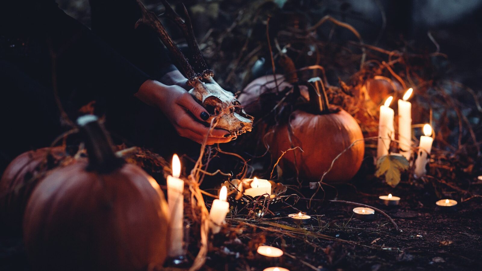 person decorating pumpkin and candles