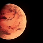 a red planet with a black background মঙ্গল গ্রহে মানুষের ভবিষ্যৎ জীবন